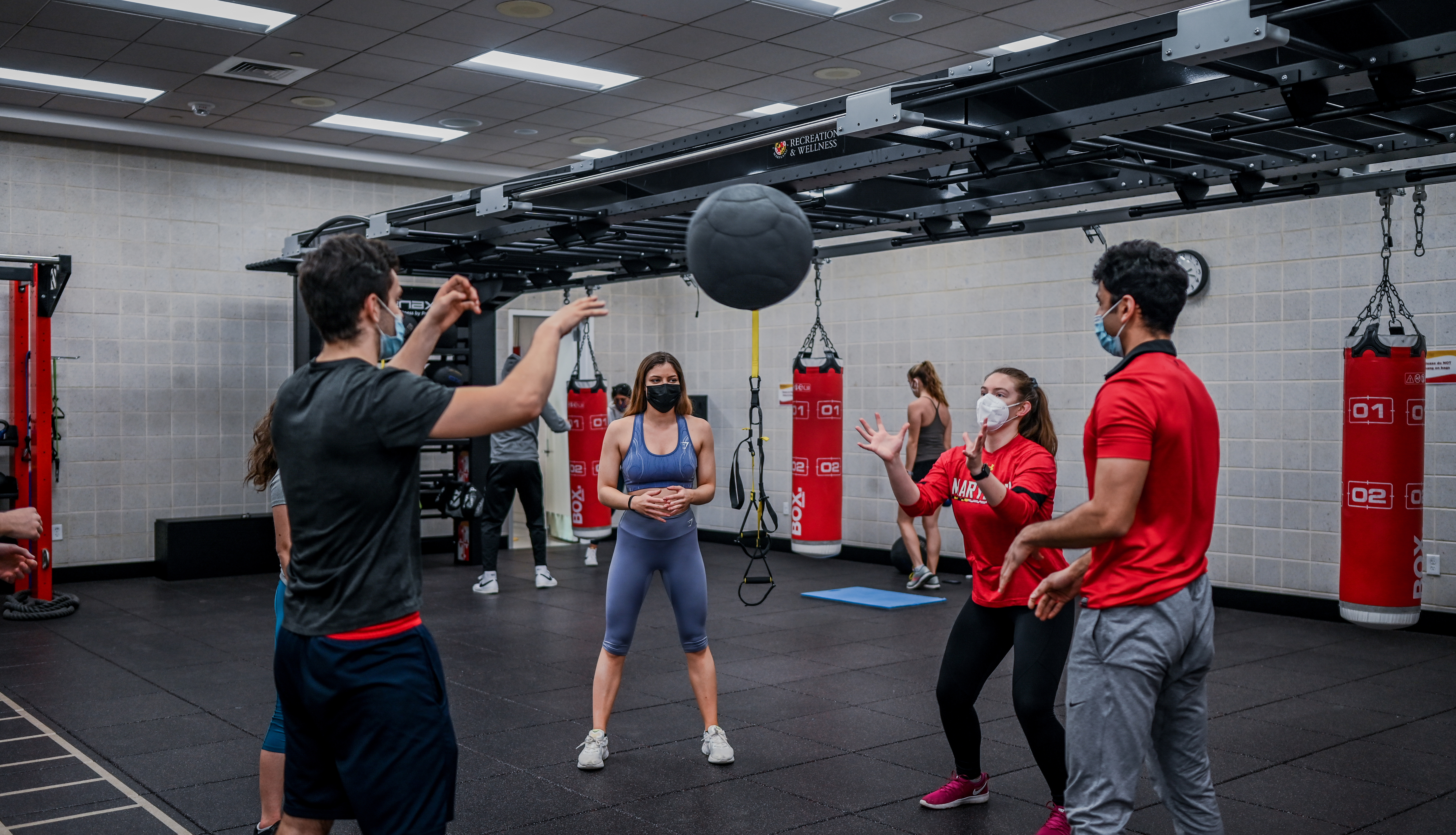 man passing medicine ball to group