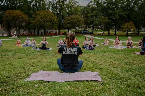 Fitness instructor in front of outdoor yoga class