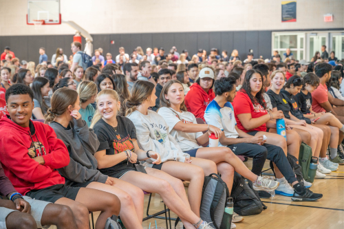 A group photo of RecWell student employees seated in a gymnasium