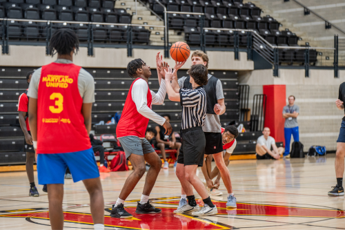Intramural basketball participants getting ready for a jump ball