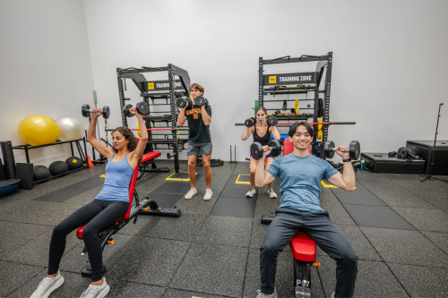 Four students lifting weights as part of the small group personal training program
