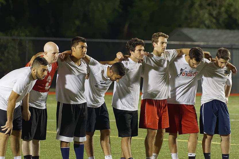 soccer players with dark shorts and white shirts standing together