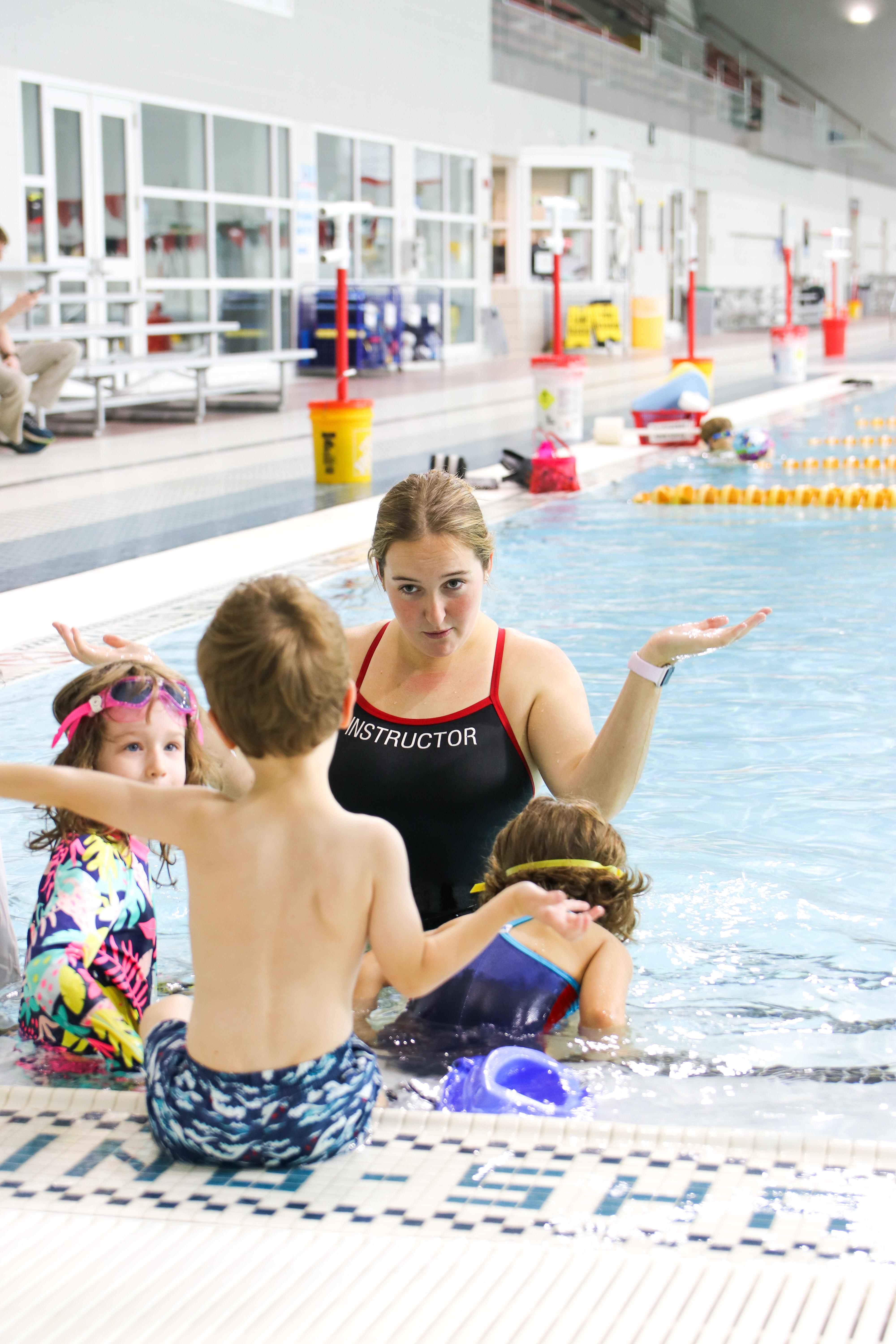 swim instructor interacting with three children during a swim lesson