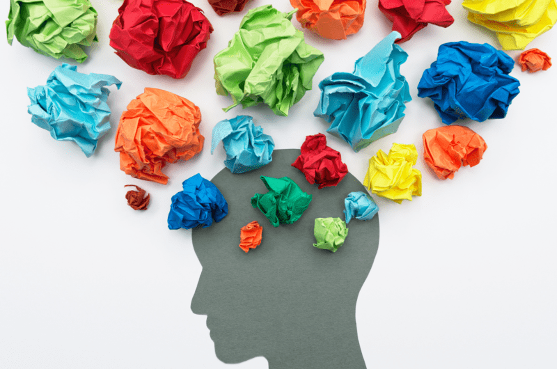 crinkled color paper coming out of persons brain