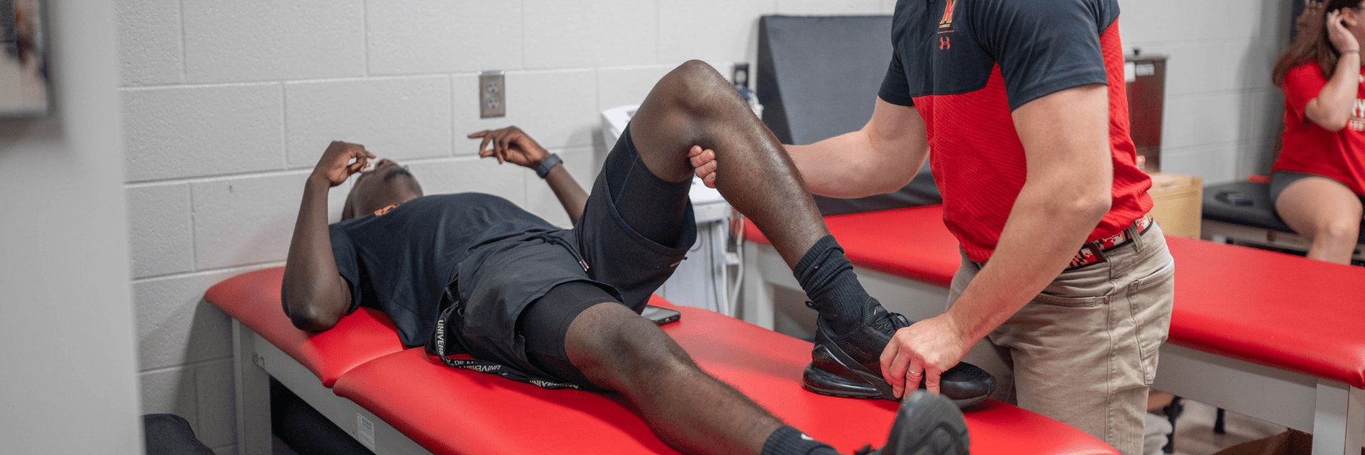 Athletic trainer consults young male with leg injury