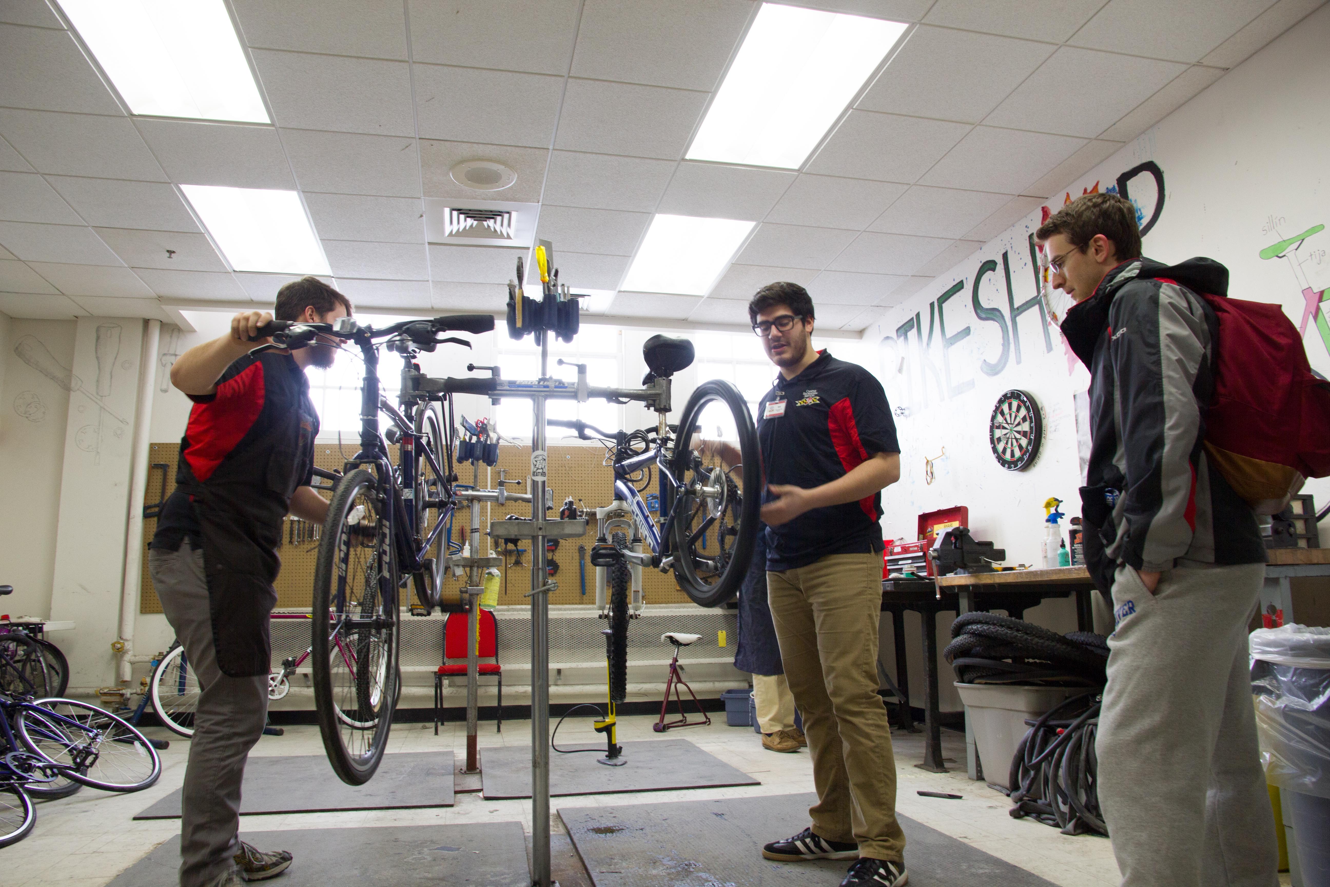 bike shop technician working with a student
