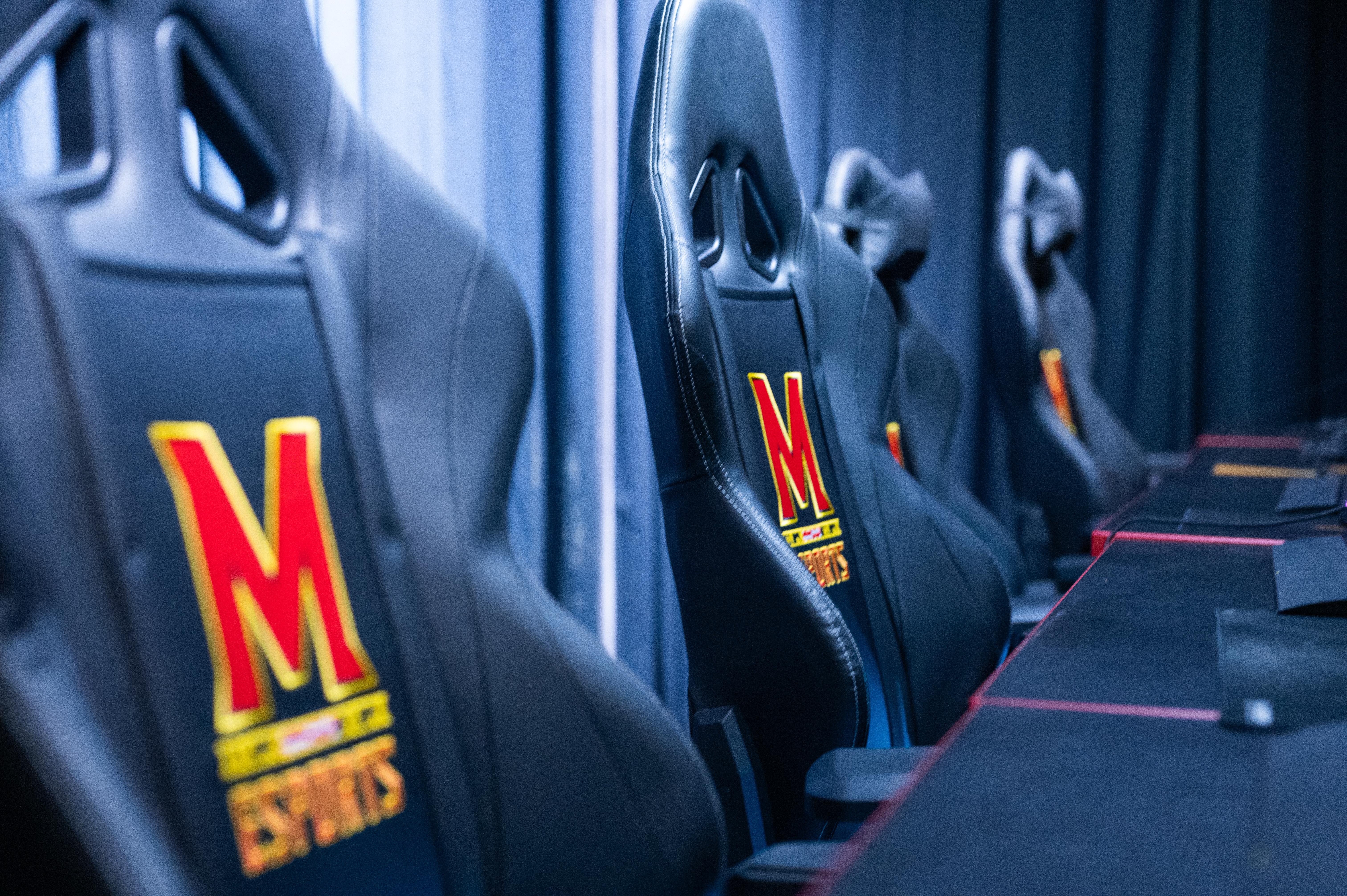 Row of M bar esports logo embroidered gamer chairs sit at their respective desks.